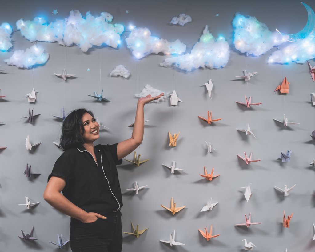 picture of artist karie and her crane wall with floating clouds