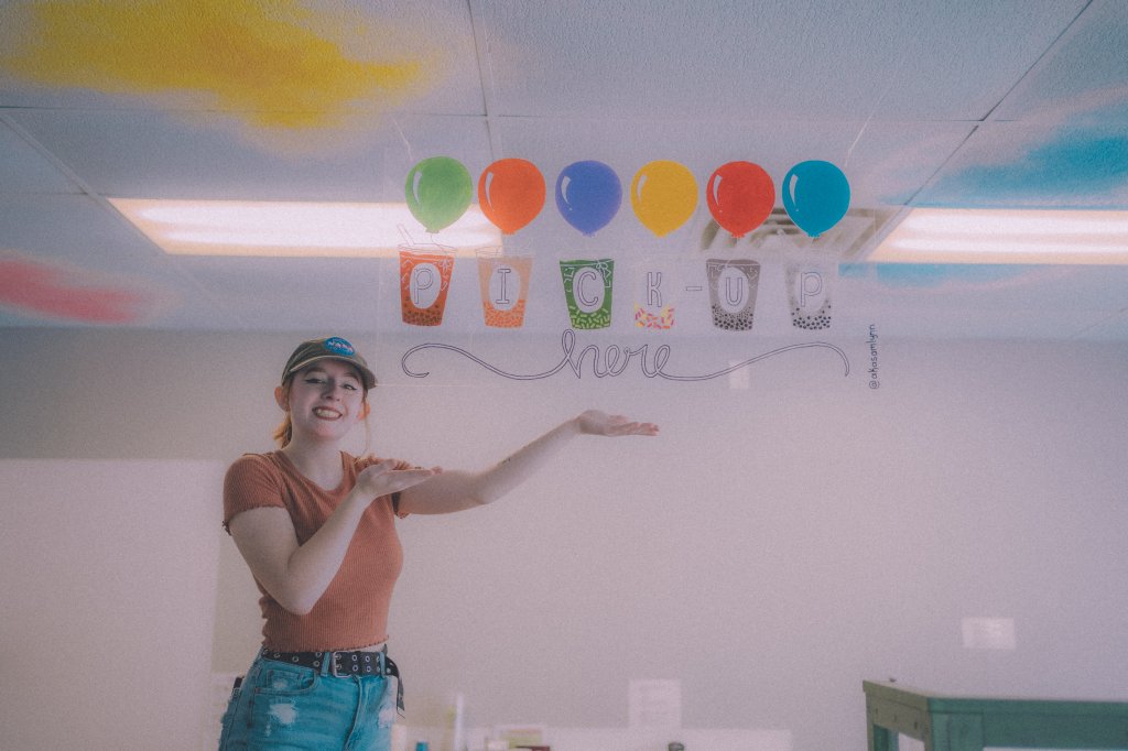 picture of artist samantha with her pick up here balloon and tea signage